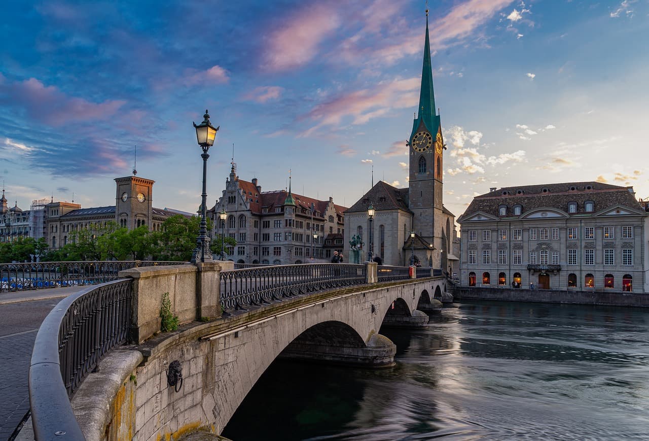 Auf dem Bild ist die Münsterbrücke über die Limmat in Zürich mit Blick auf die Fraumünsterkirche und das Zunfthaus zur Meisen zu sehen.